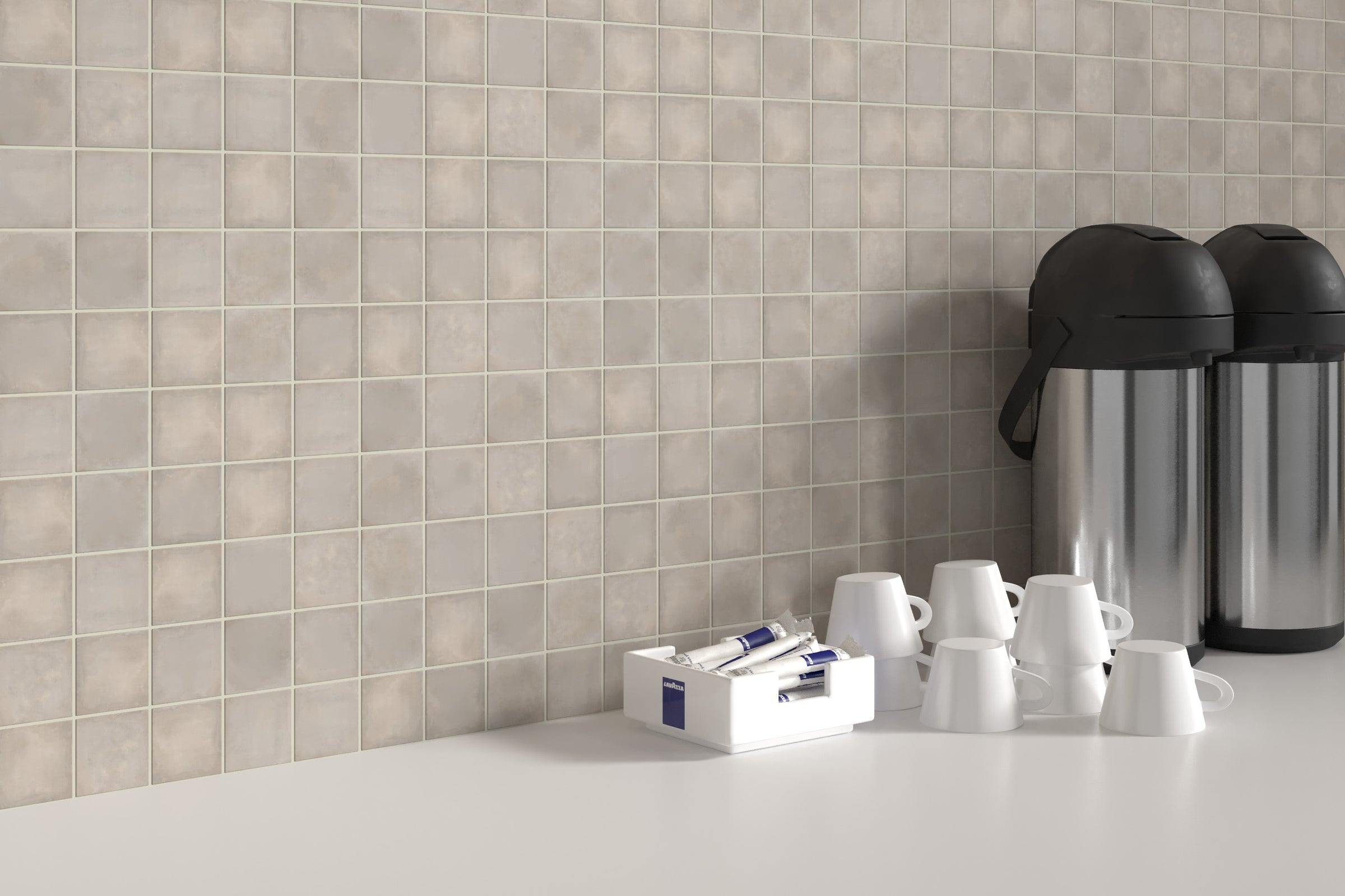 A white counter top with cups and coffee pot.