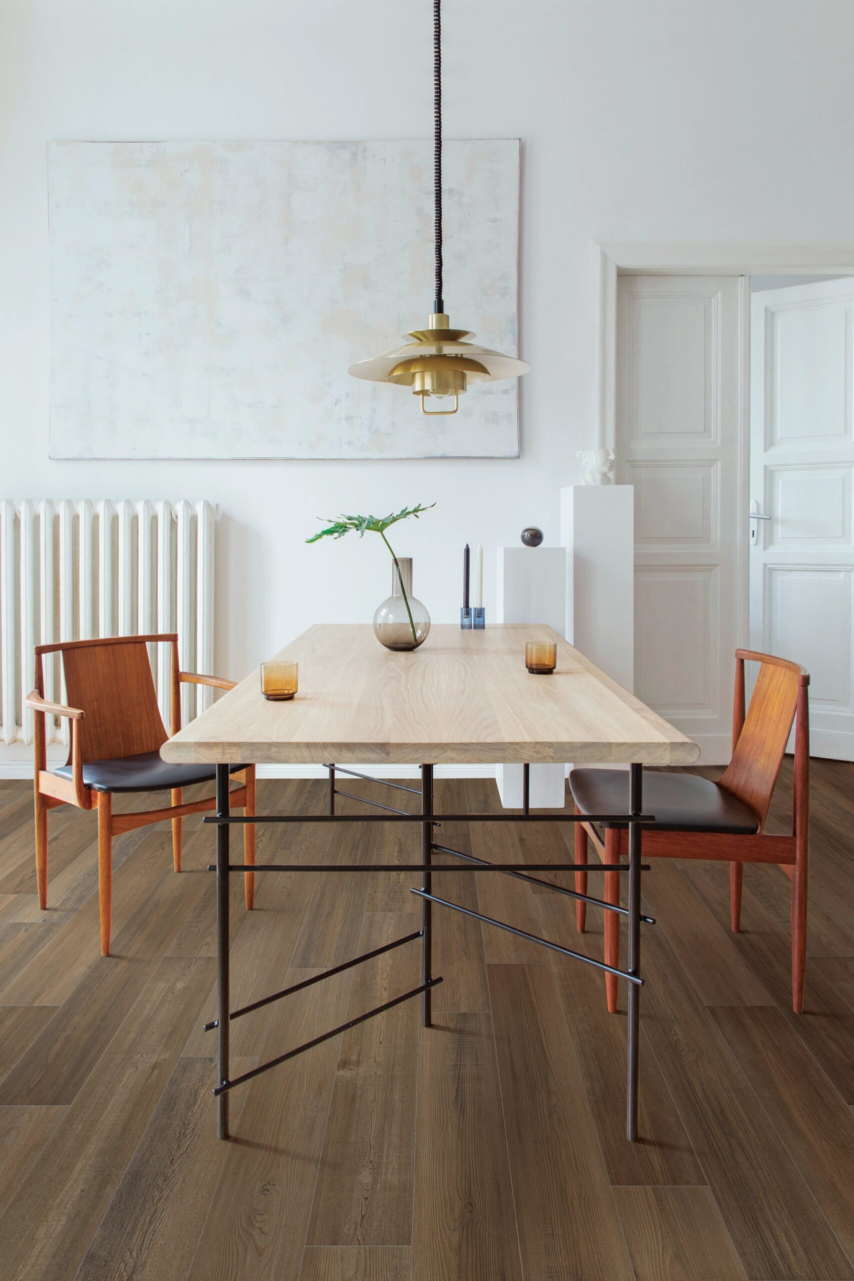 A dining room table with two chairs and a radiator