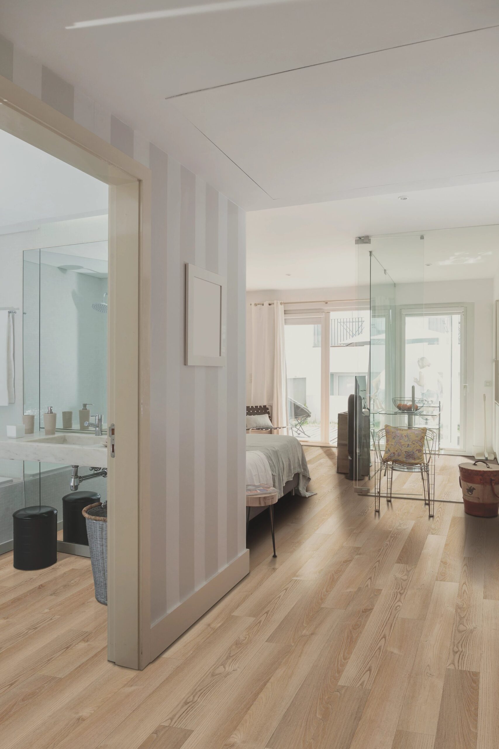 A bedroom with a glass door and wooden floors