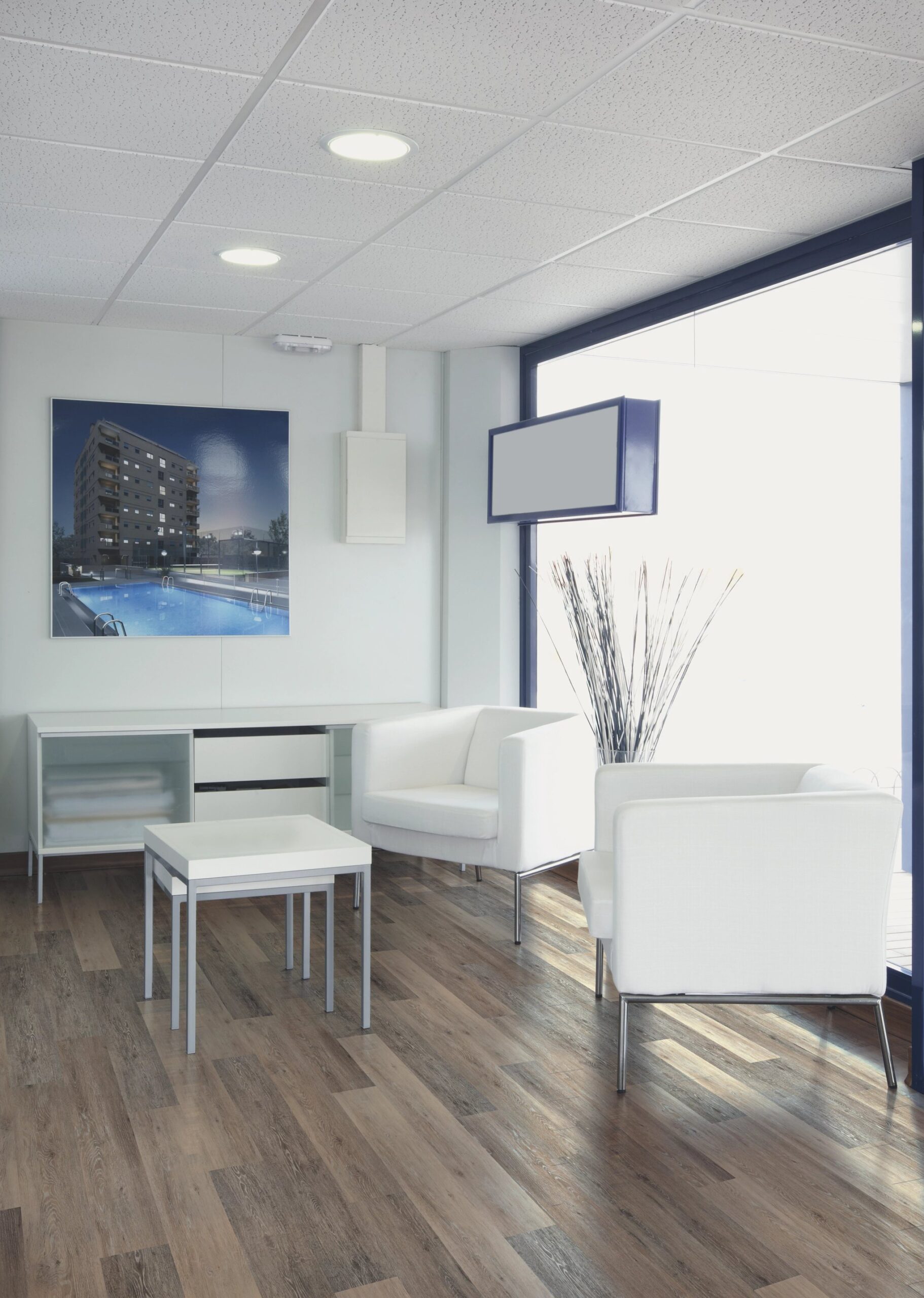 A room with white furniture and a large window.