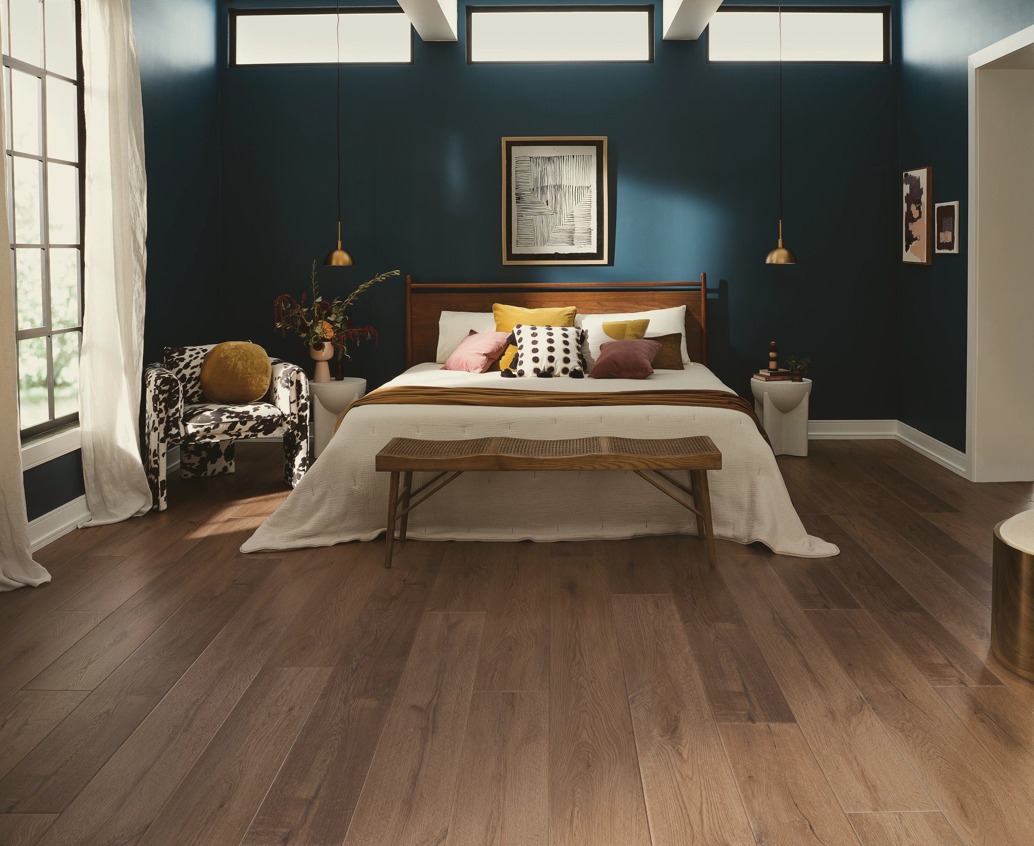A bedroom with hardwood floors and a bed.