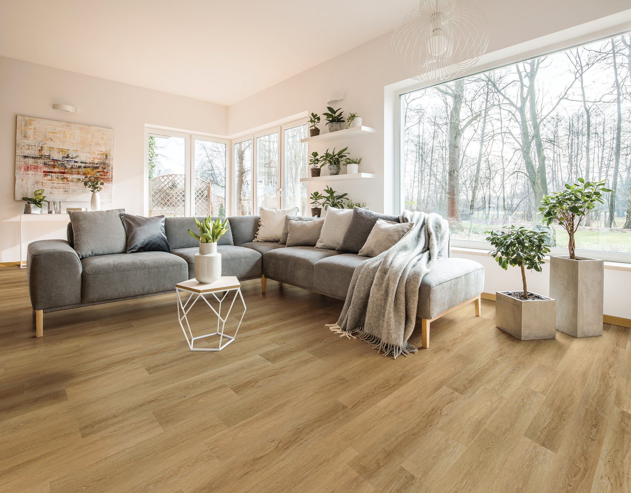 A living room with wooden floors and grey furniture.