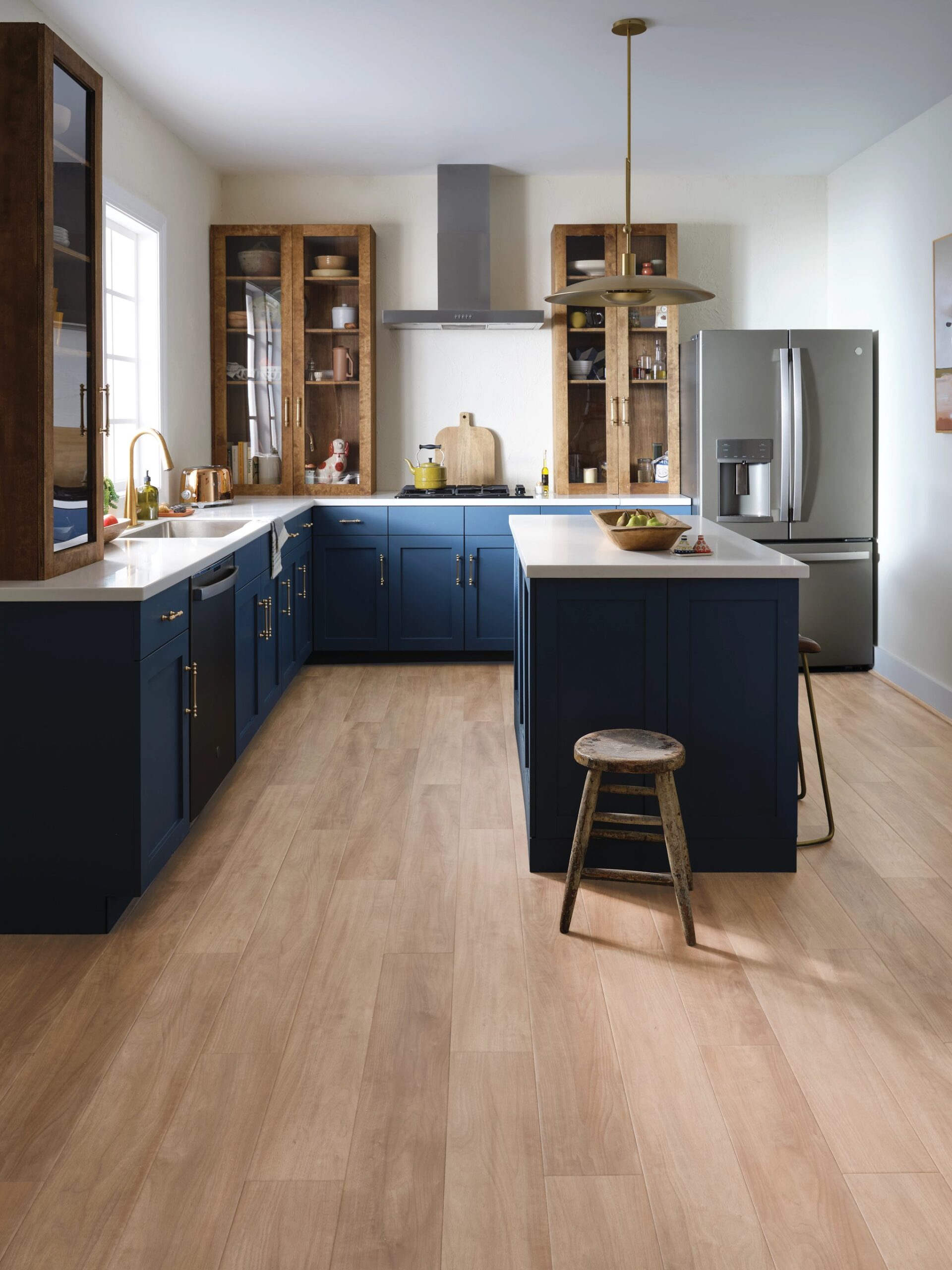A kitchen with blue cabinets and wooden floors.