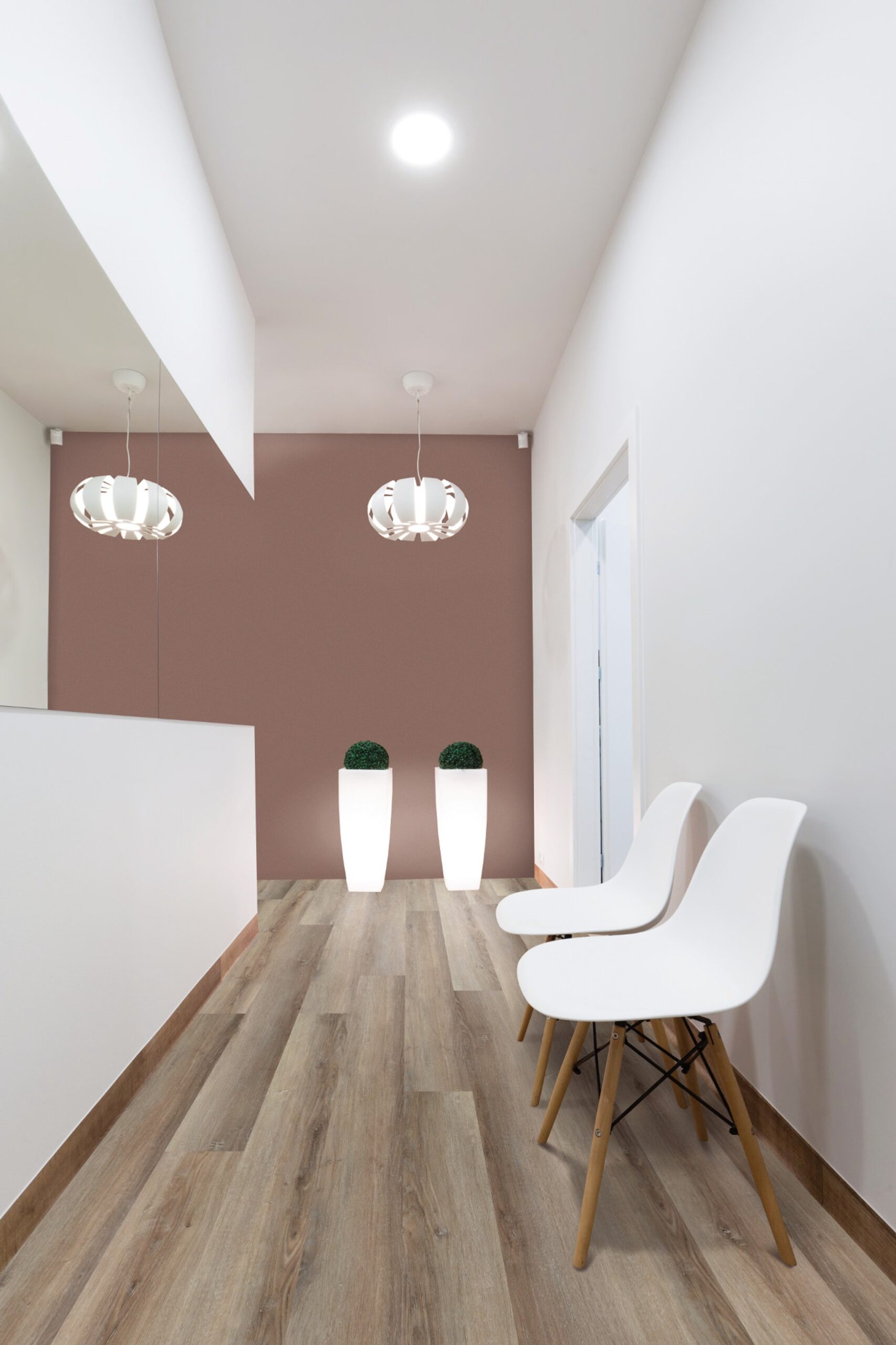 A room with two white chairs and a pink wall
