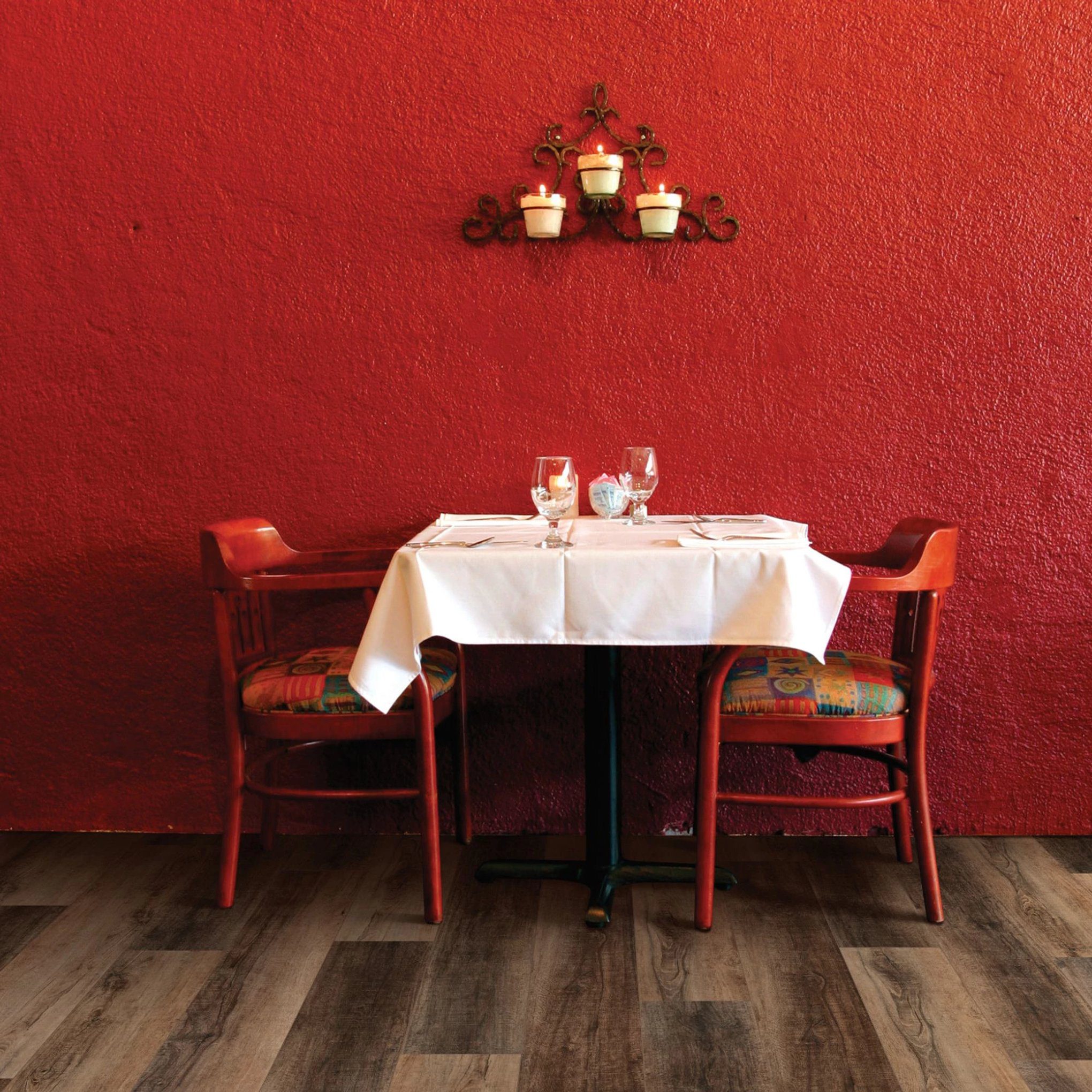 A table with two chairs and a wine glass on it.