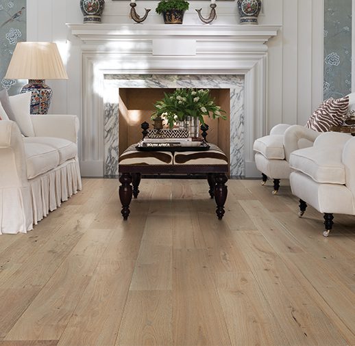 A living room with white furniture and fireplace.