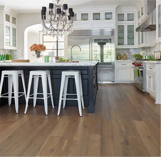 A kitchen with white cabinets and black island.