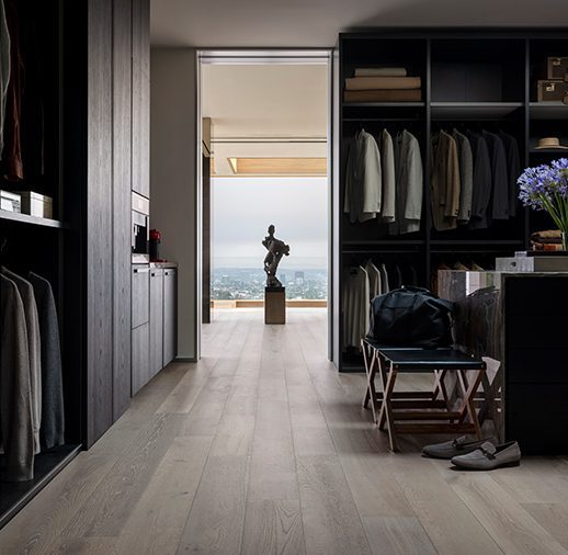 A walk in closet with black cabinets and a view of the ocean.