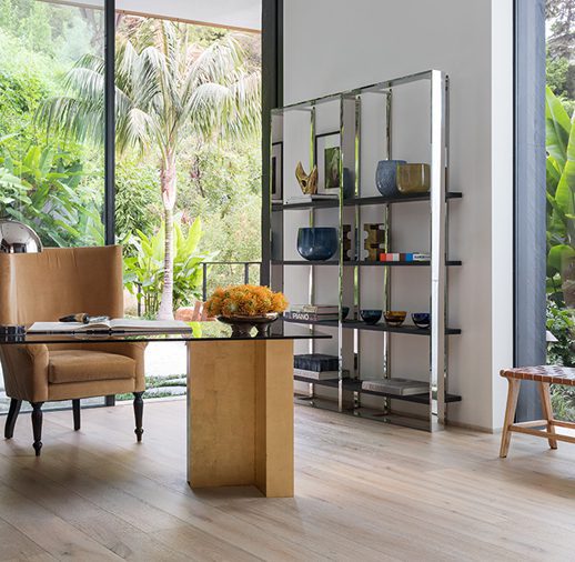 A room with a table and chairs, a chair and a bookshelf.