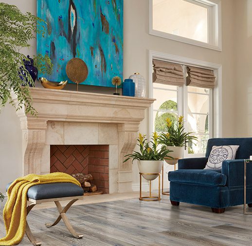 A living room with blue furniture and a fireplace.