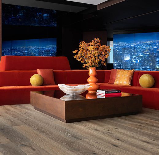 A living room with red couches and orange pillows