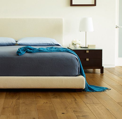 A bed with blue sheets and pillows on it