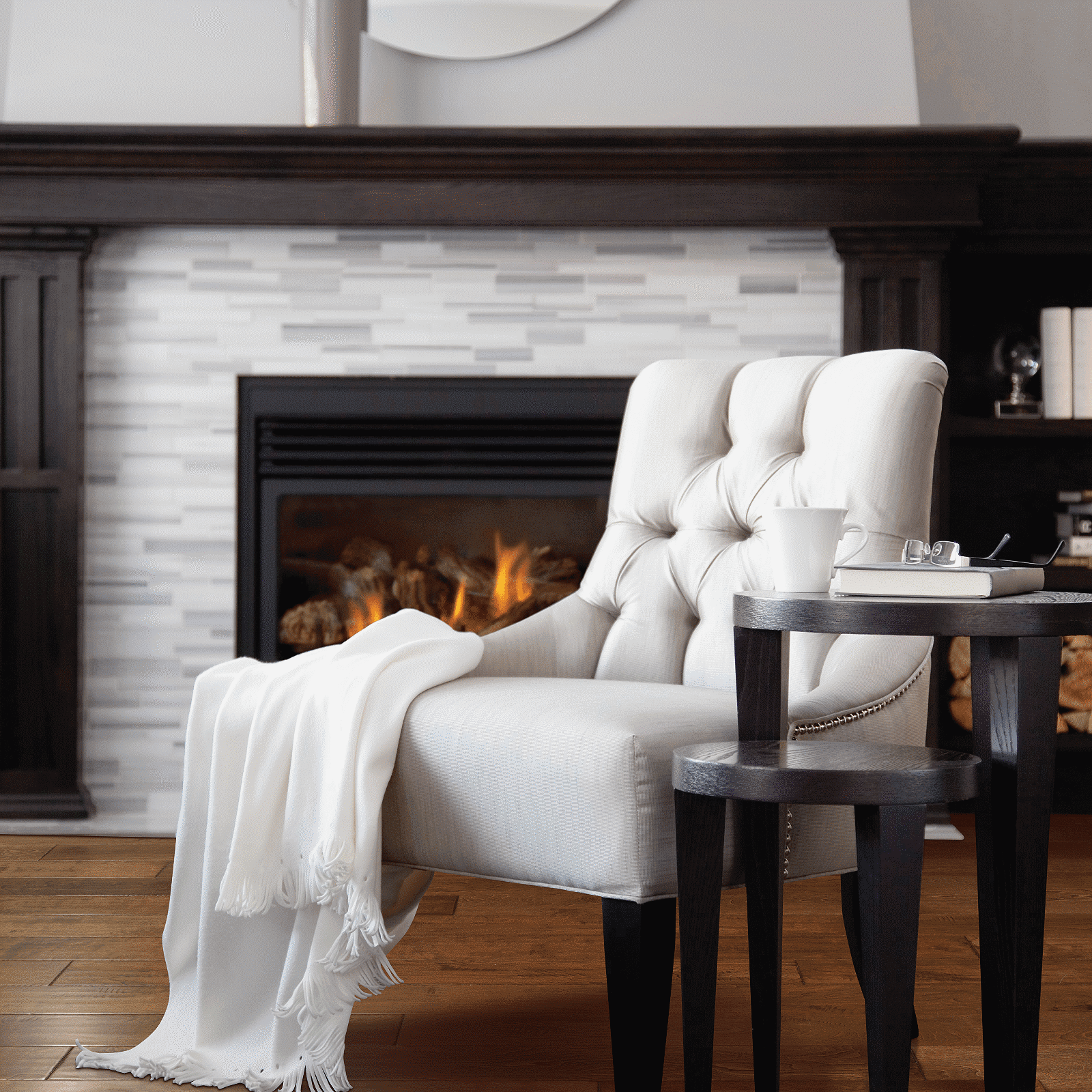 A white chair in front of a fireplace.