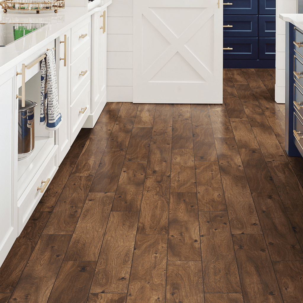 A kitchen with wooden floors and white cabinets.