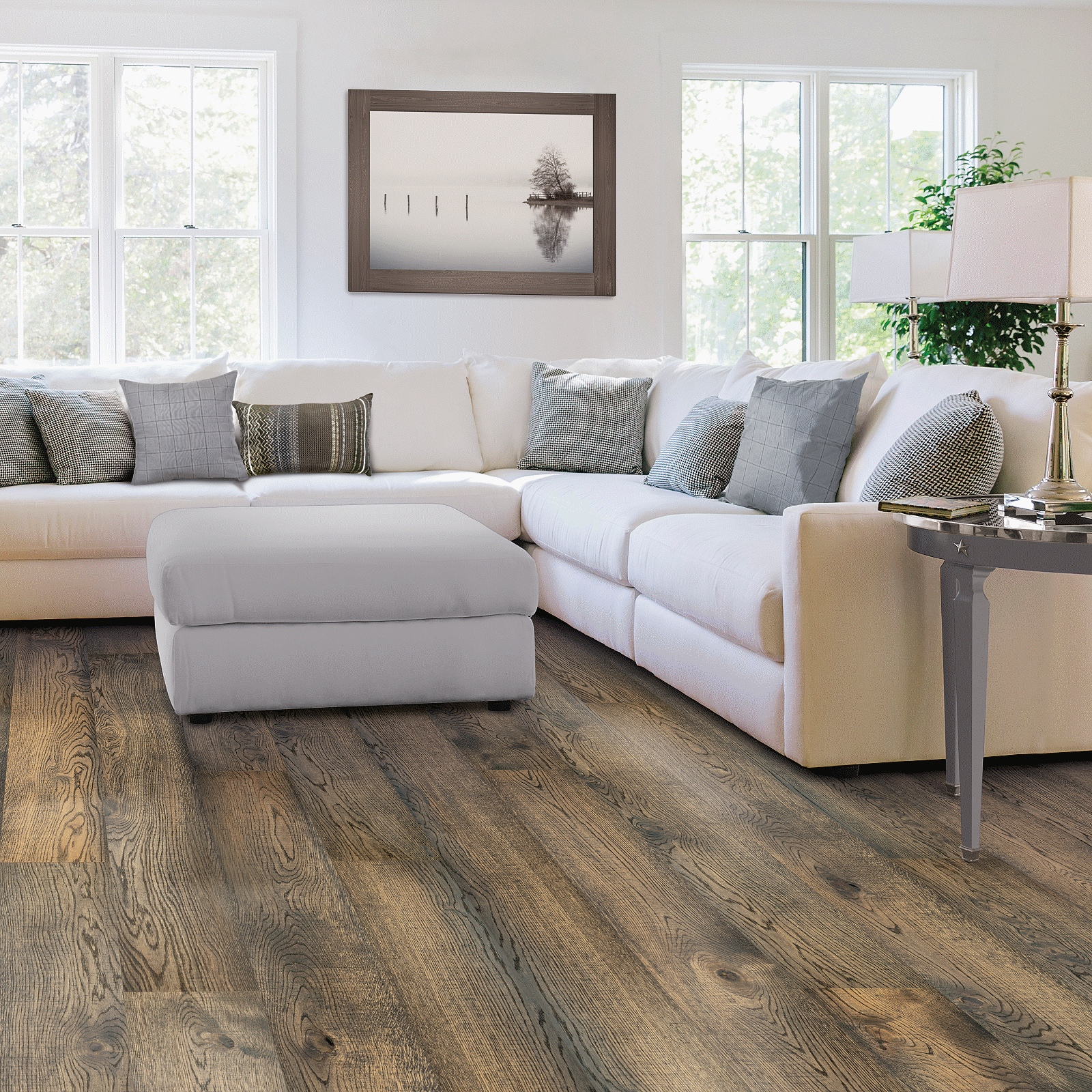 A living room with white furniture and wood floors.