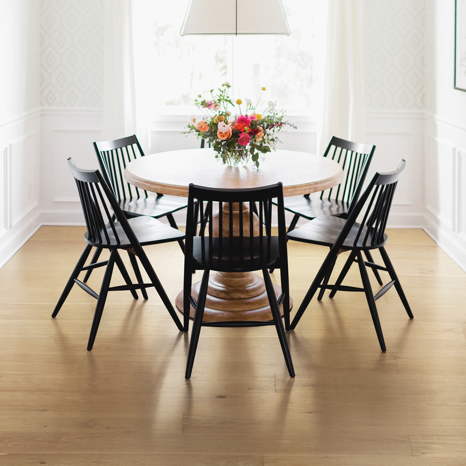 A dining room table with six black chairs.
