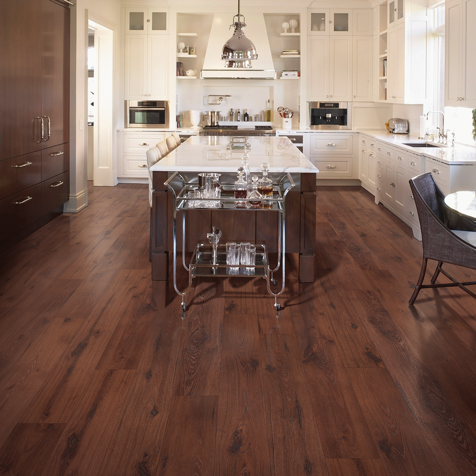 A kitchen with wood floors and white cabinets.