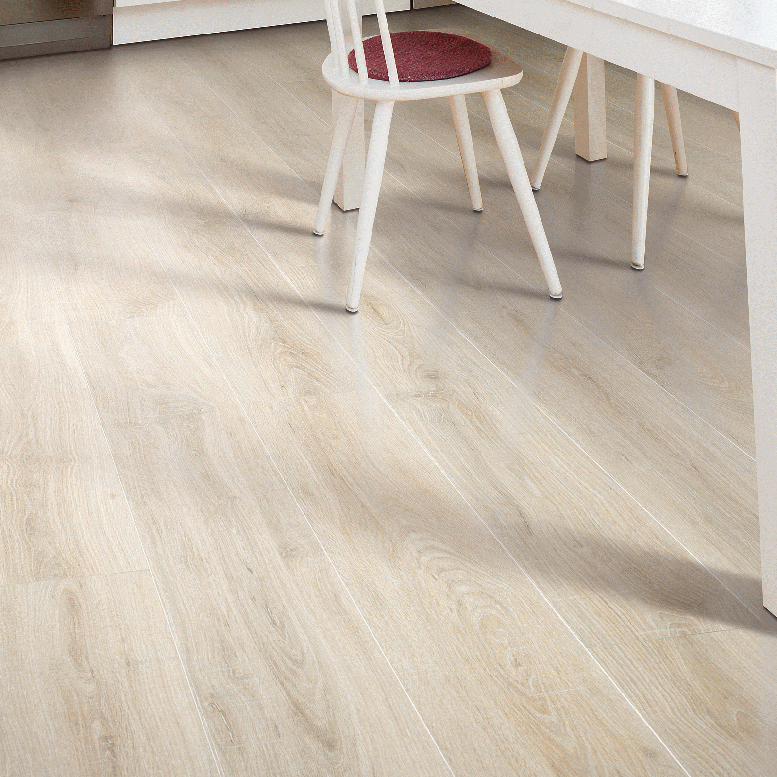 A white table and chair in front of a wooden floor.