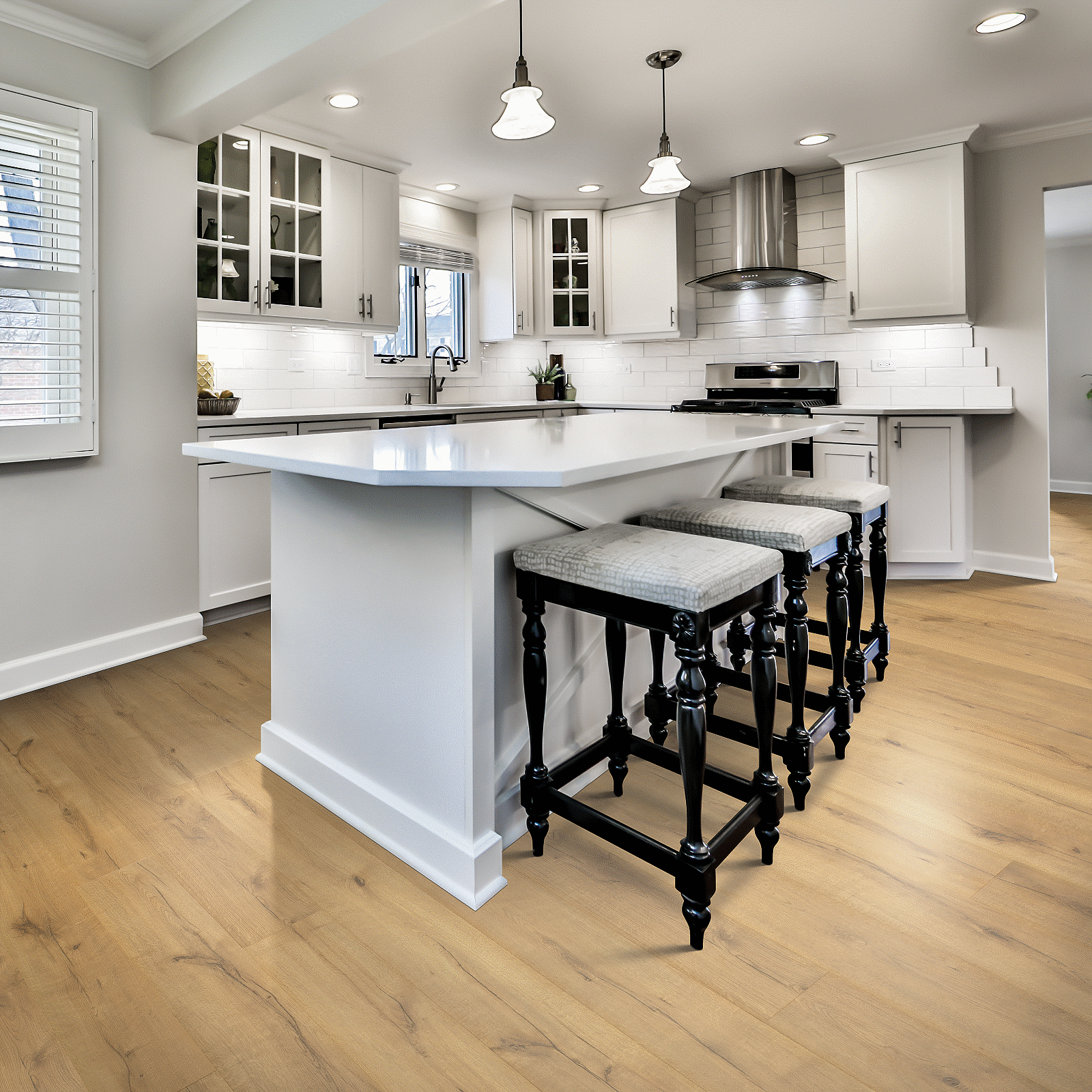 A kitchen with white cabinets and black stools.