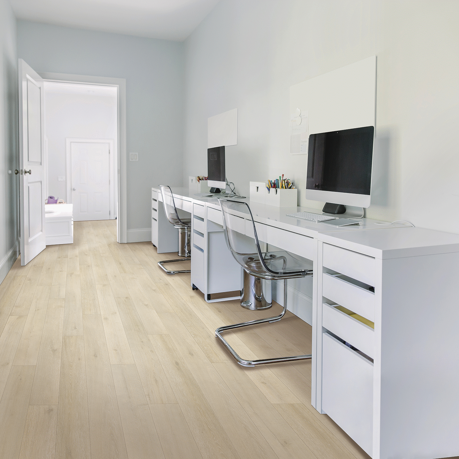 A room with two desks and chairs, one of which has a computer on it.