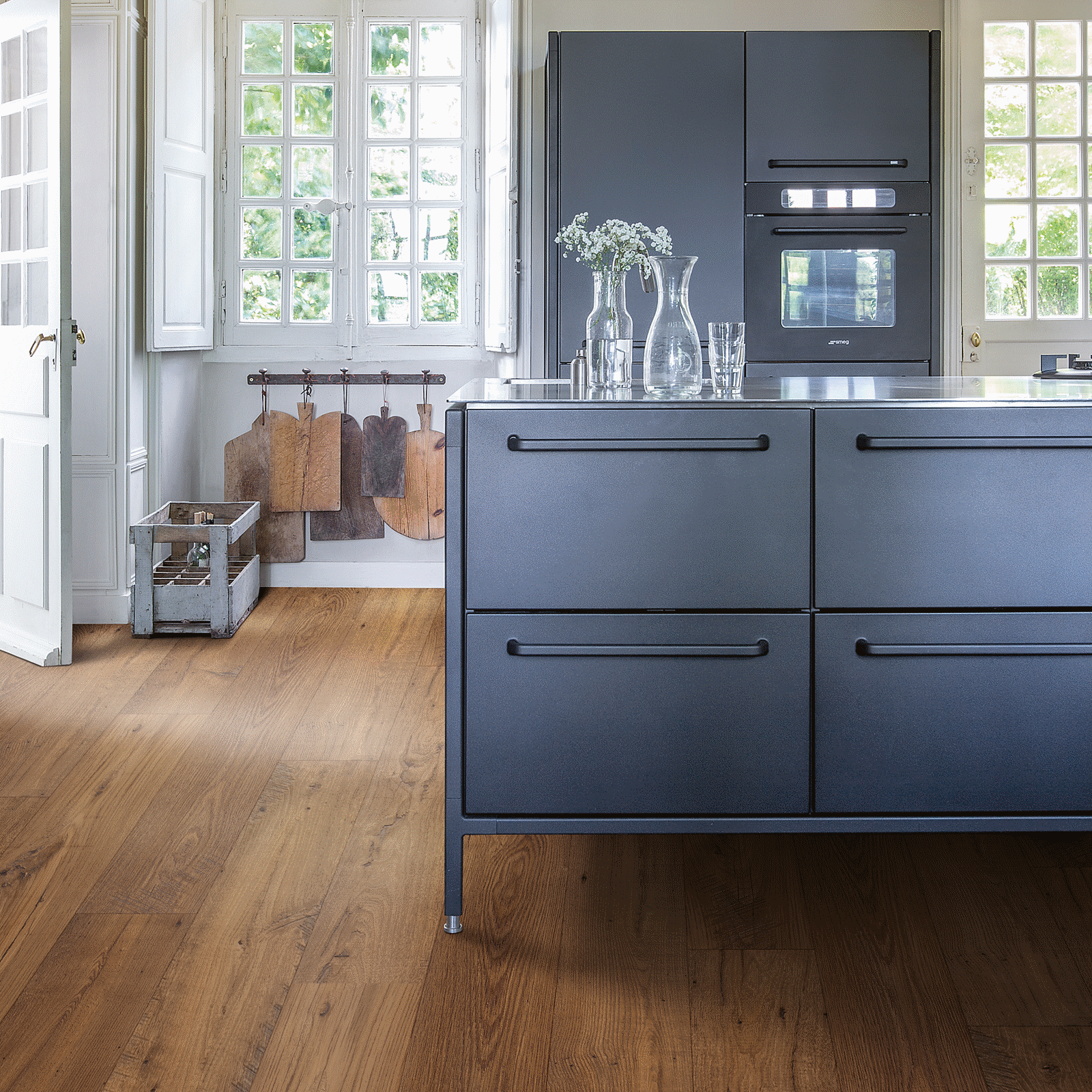 A kitchen with wood floors and blue cabinets.