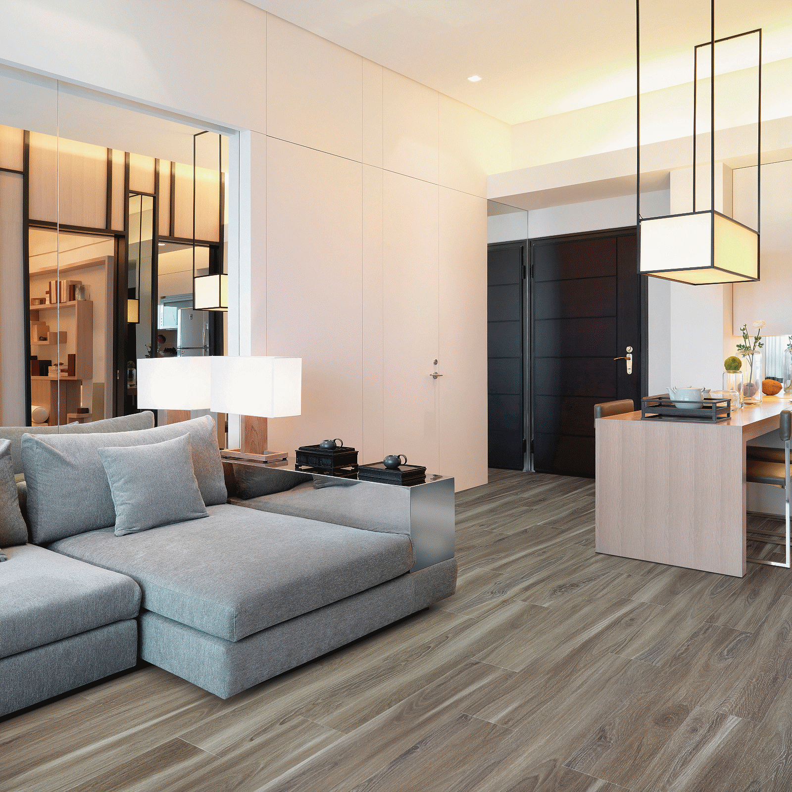 A living room with grey couches and white walls.