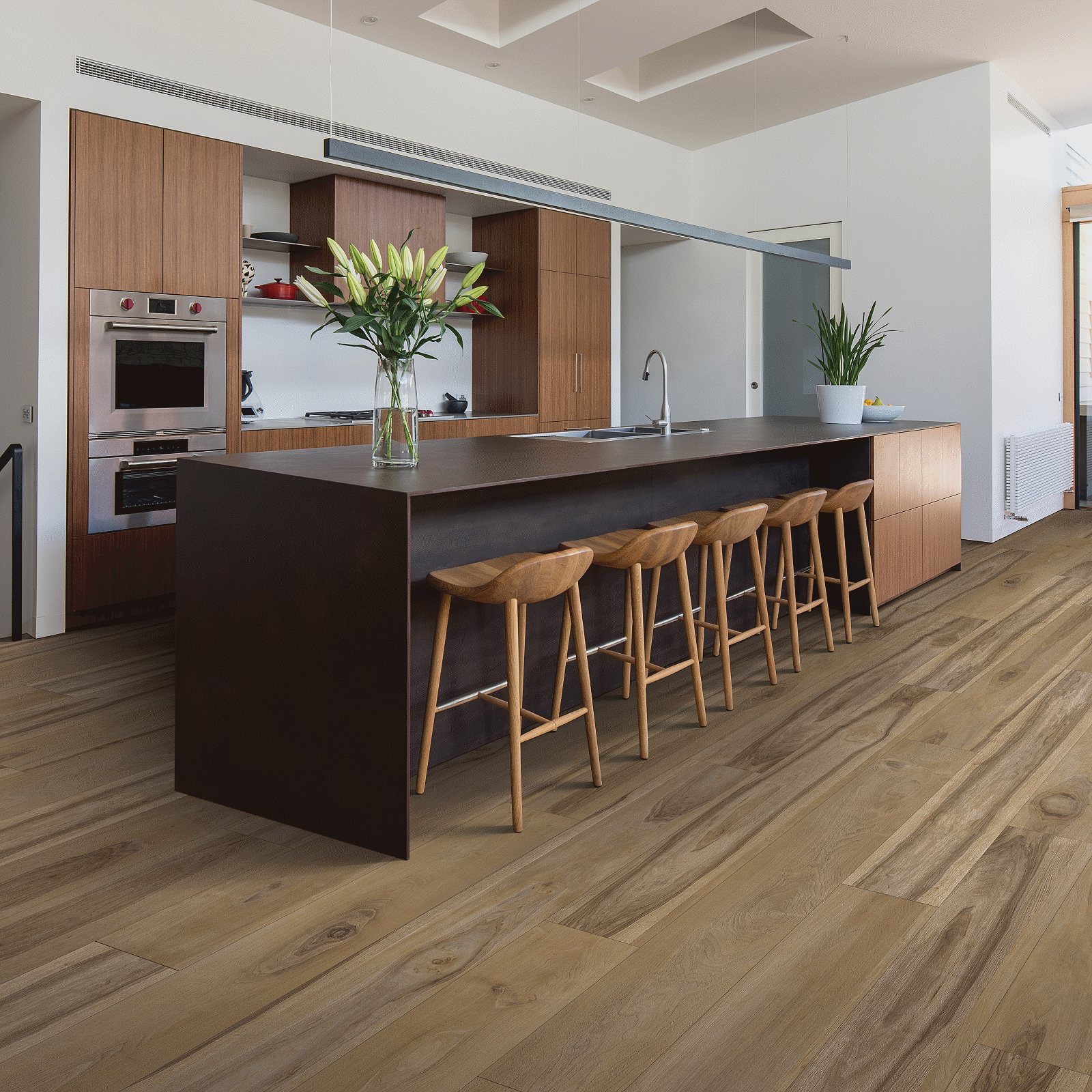 A kitchen with wooden floors and a bar.