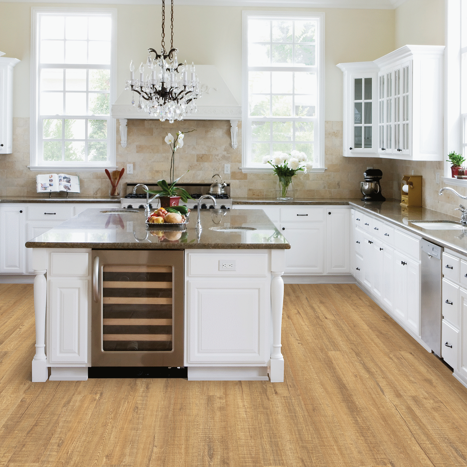 A kitchen with white cabinets and wood floors.