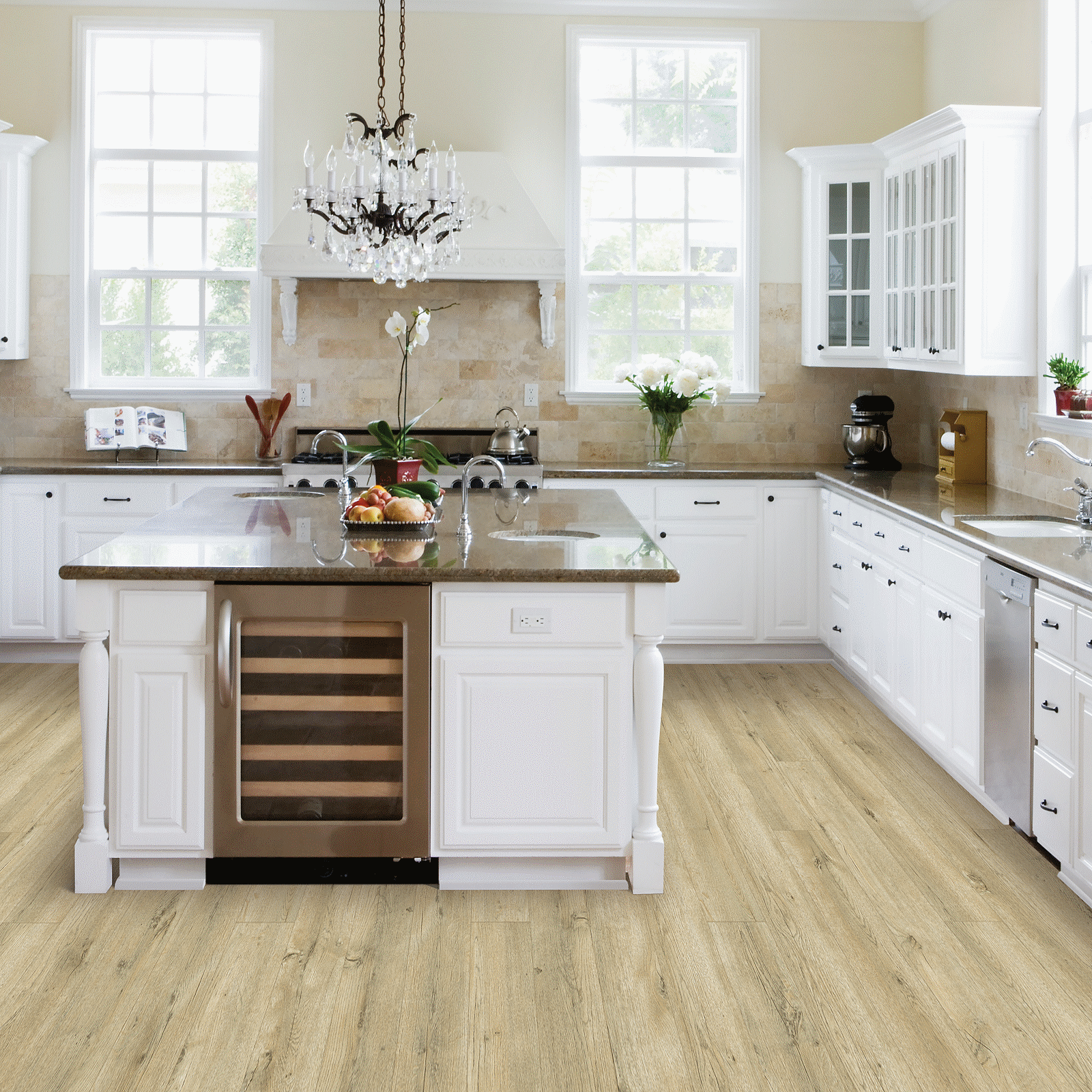 A kitchen with white cabinets and wood floors.