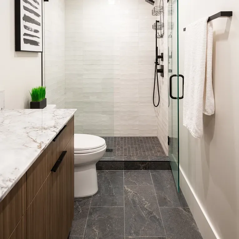 A bathroom with a toilet, shower and sink.