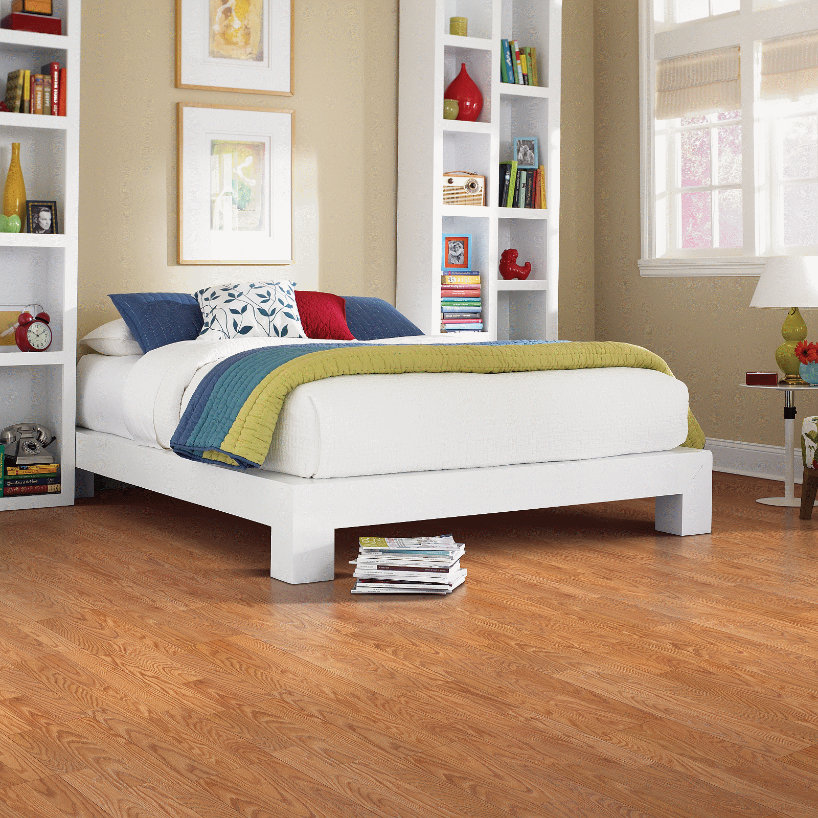 A bedroom with hard wood floors and white furniture.