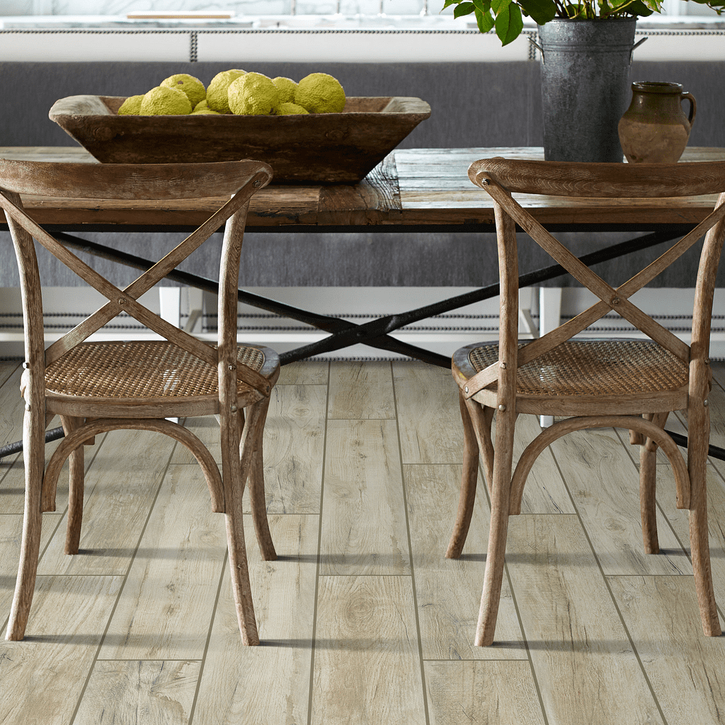 A dining room table with two chairs and fruit on the table.