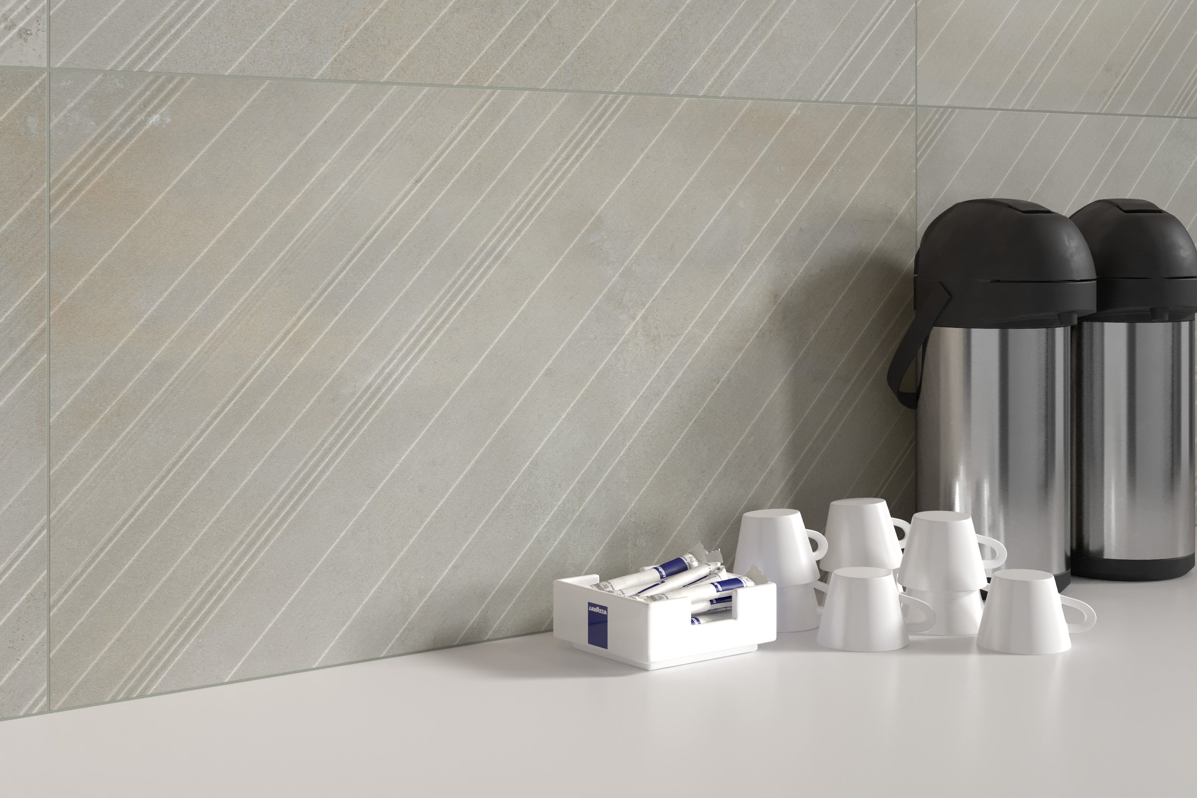 A white counter top with cups and coffee pot.
