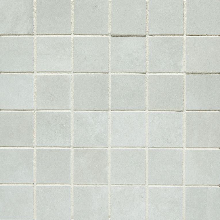 A white tile wall with some small squares