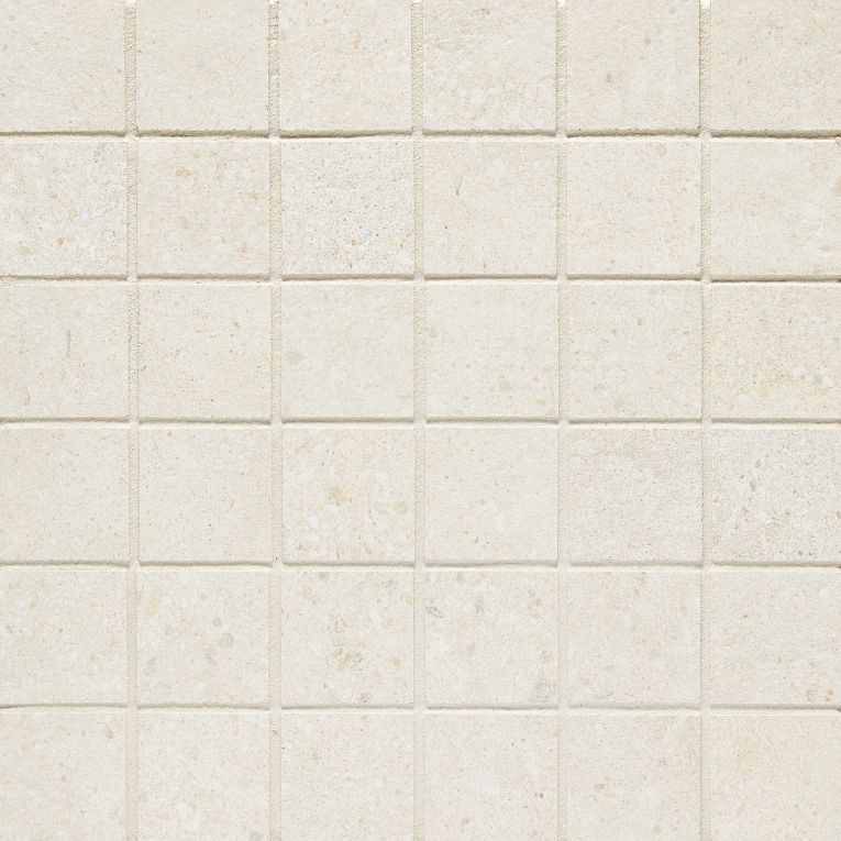 A white tile wall with some small squares