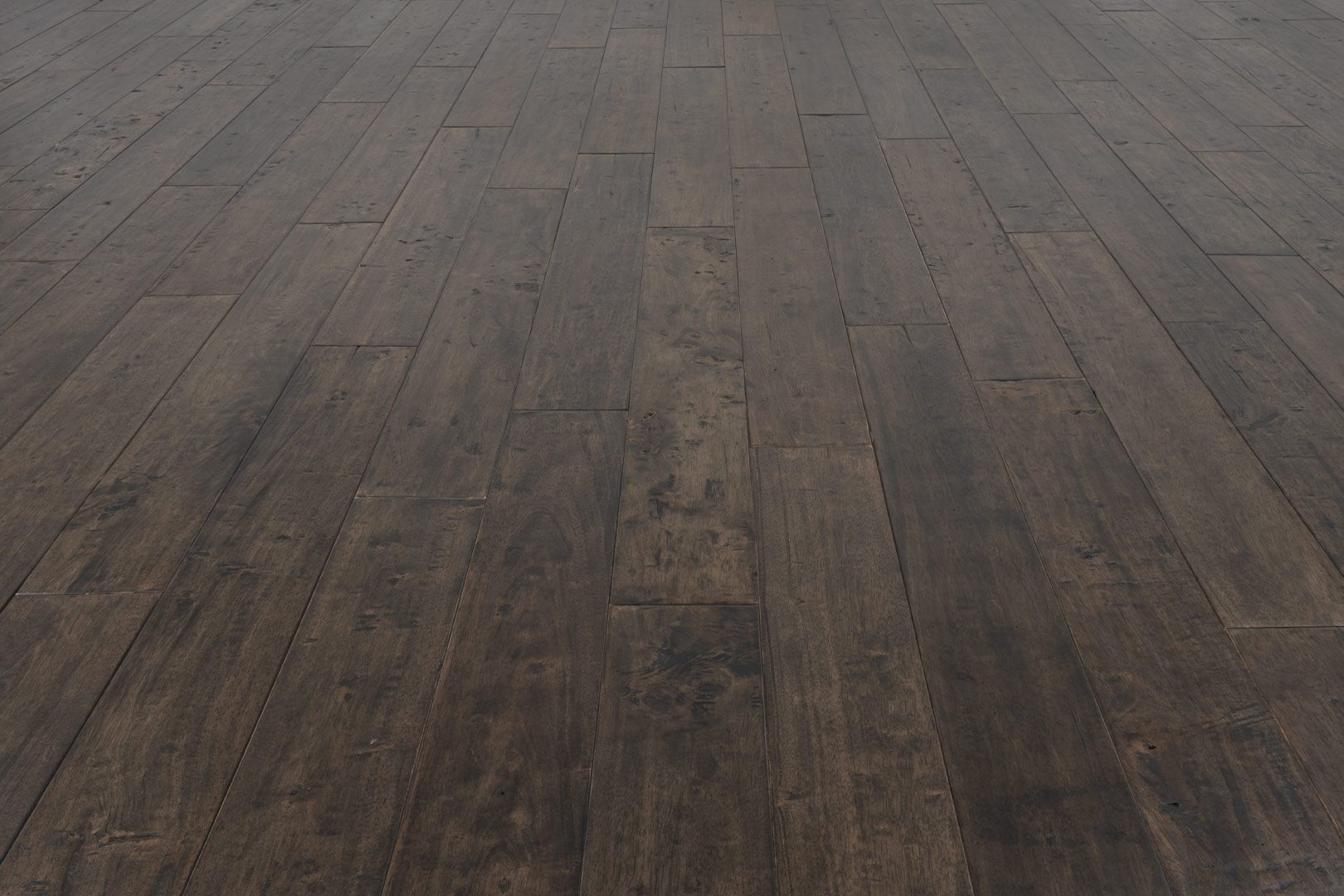 A dark wood floor with some brown lines