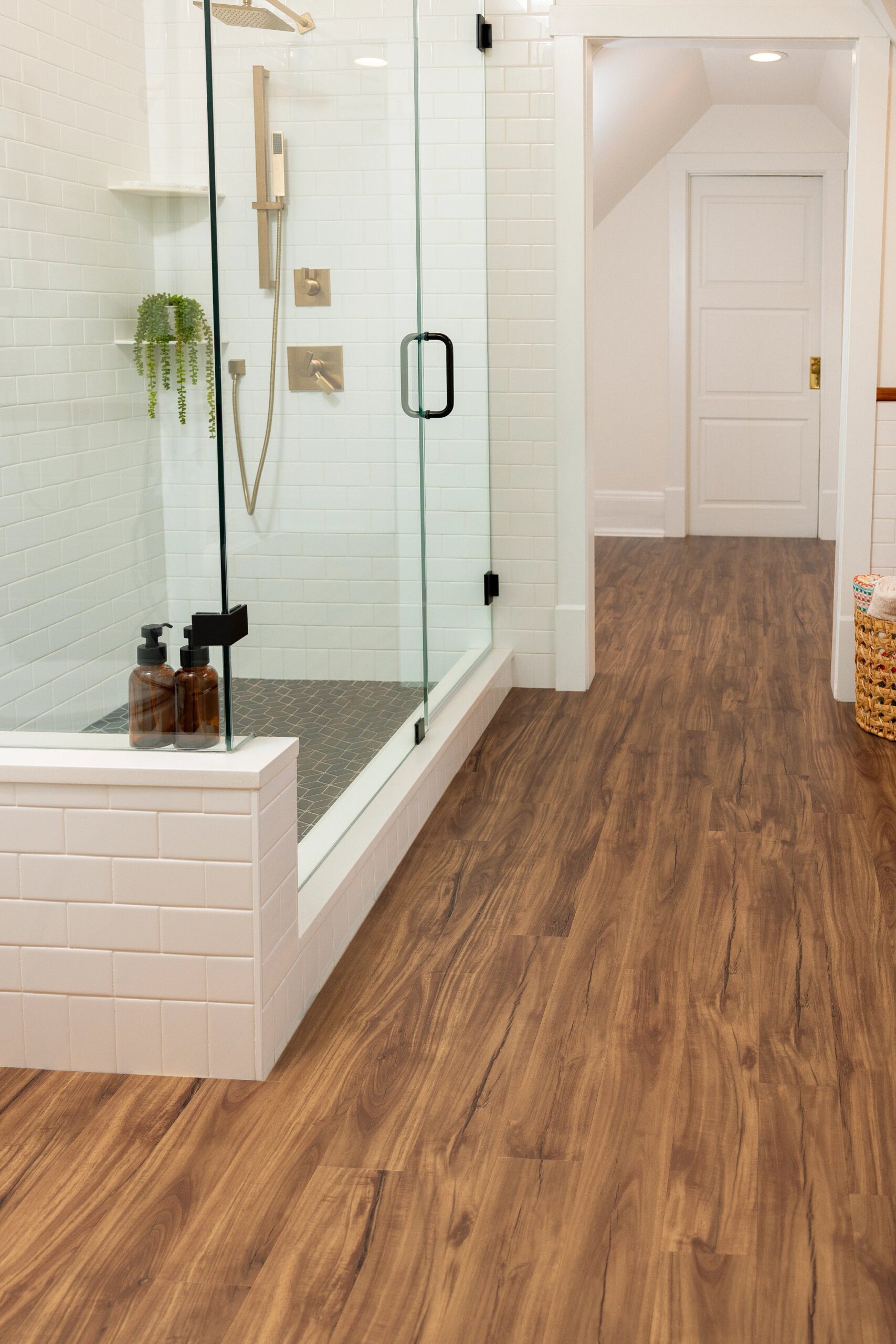 A bathroom with wood floors and white walls.