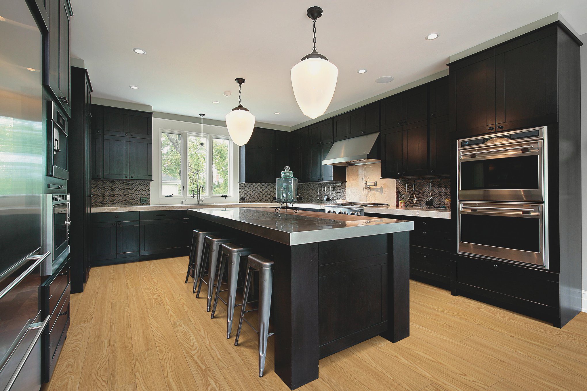 A kitchen with black cabinets and white counters.