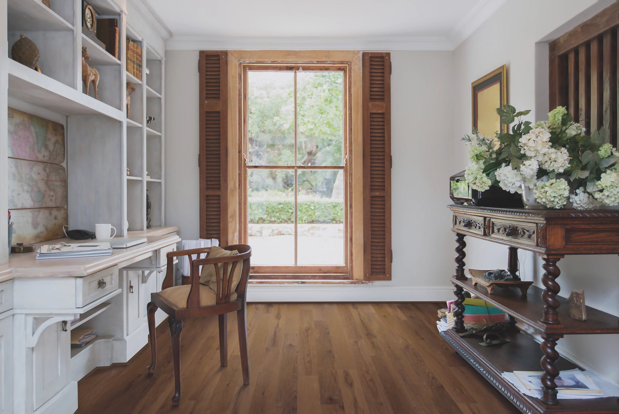 A room with wooden floors and a desk.