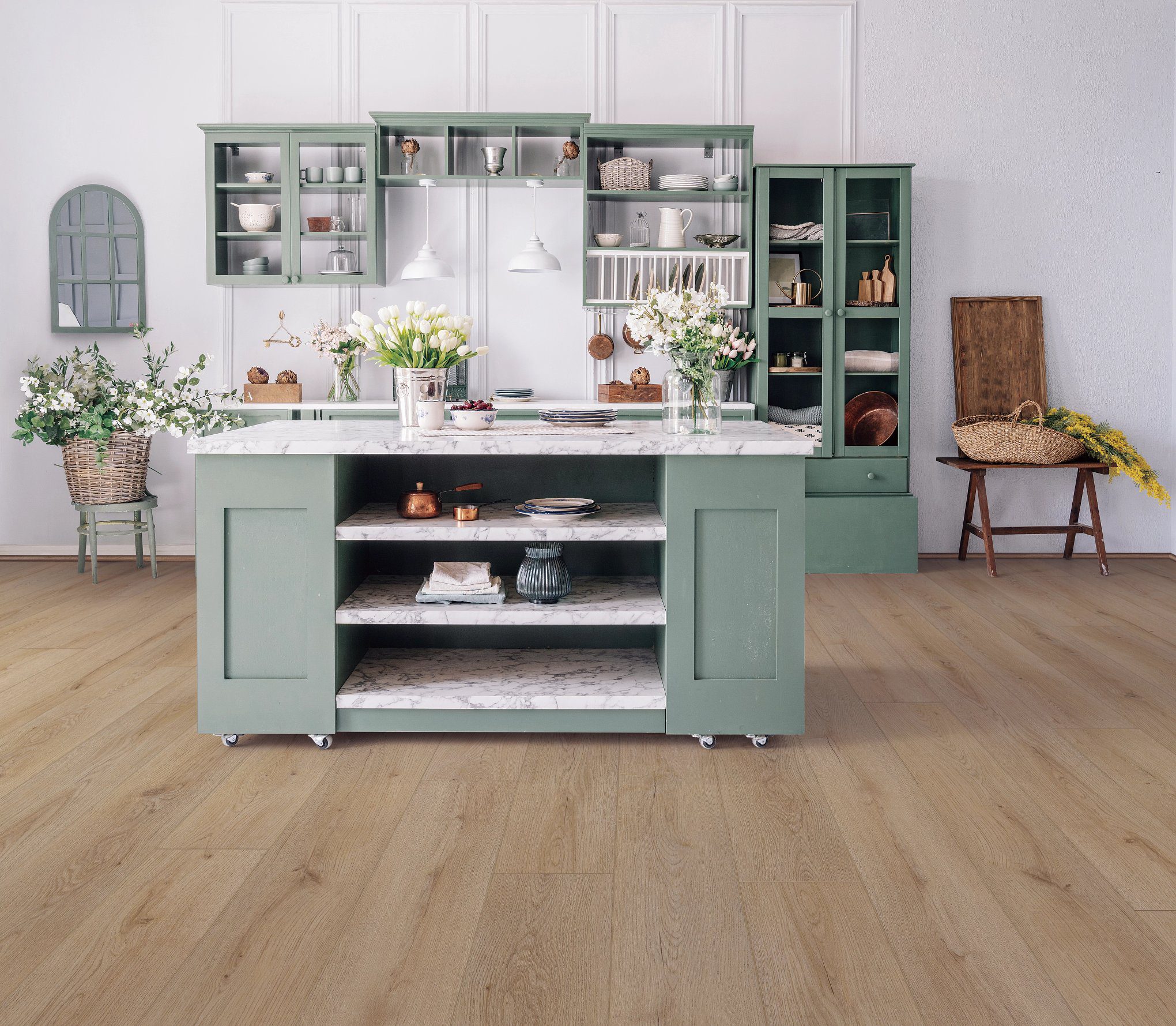 A kitchen with green cabinets and wooden floors.