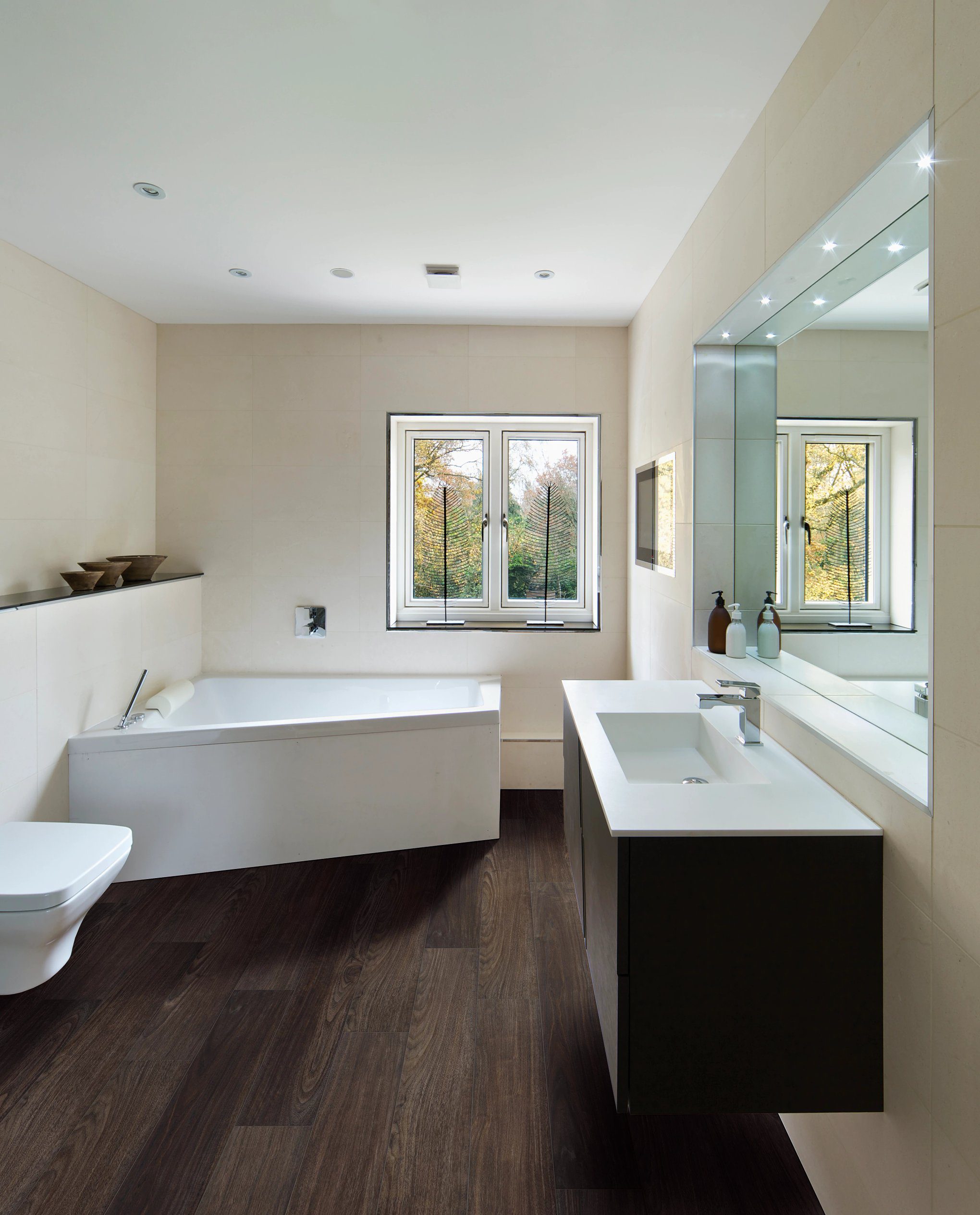 A bathroom with wood floors and white walls.