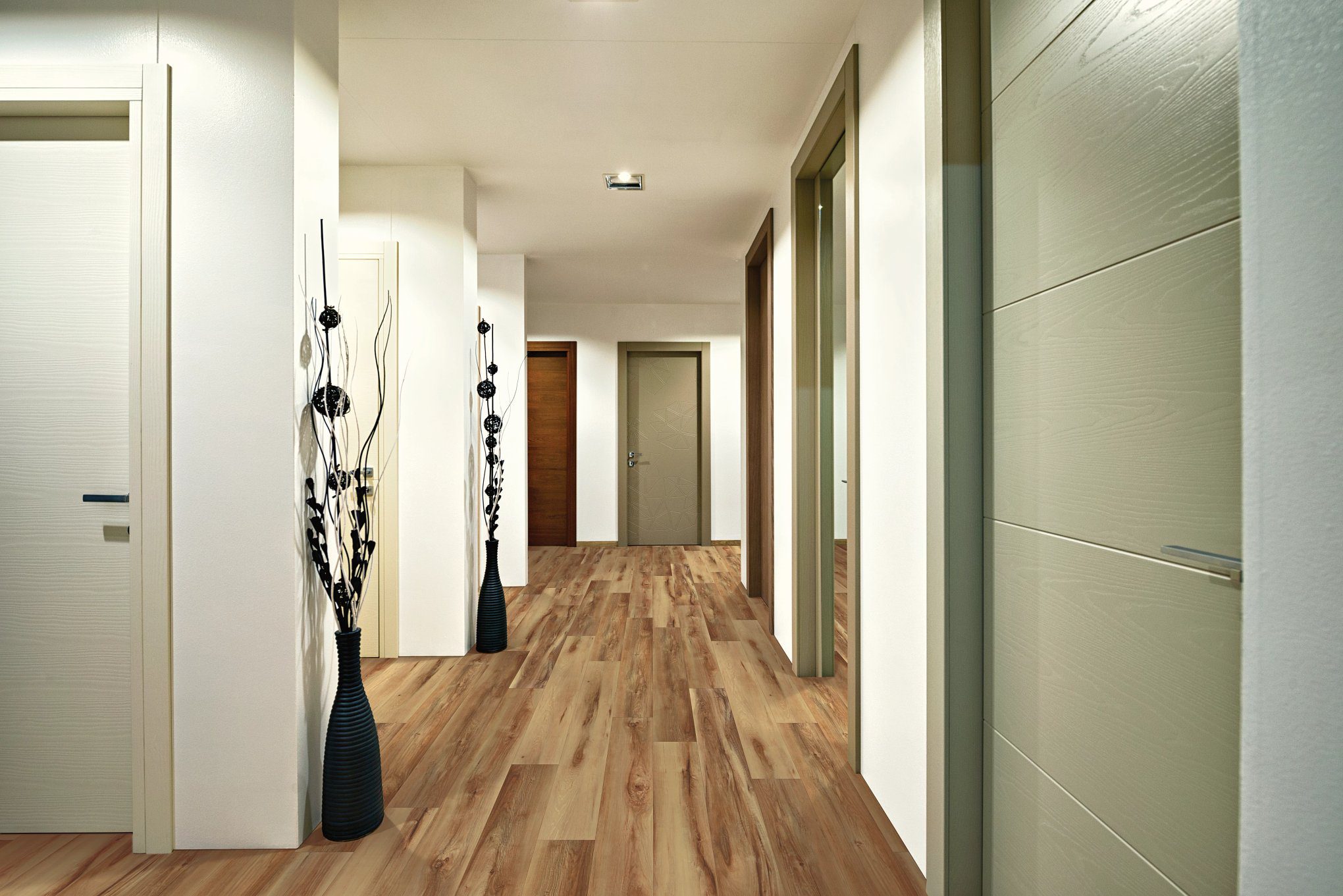 A hallway with wooden floors and white walls.