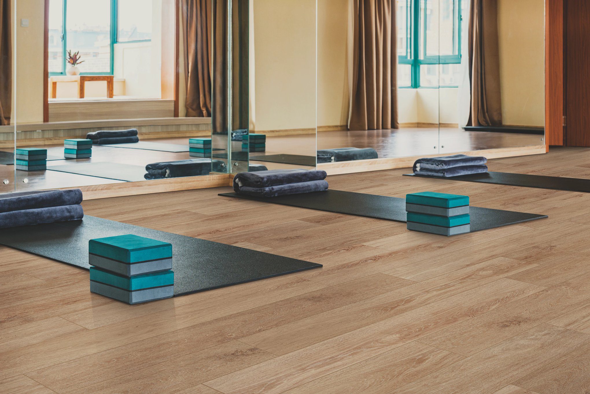 A room with several yoga mats and blocks on the floor.