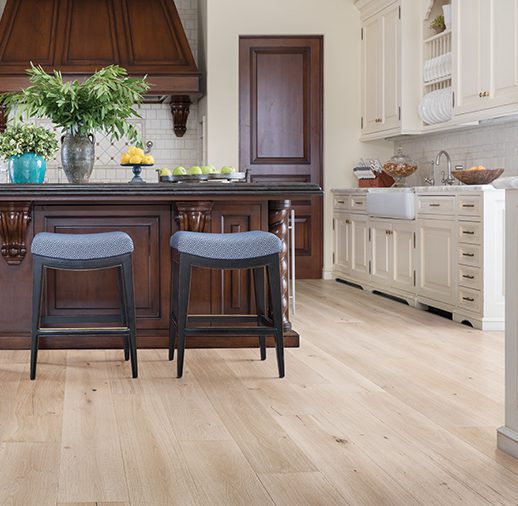 A kitchen with two stools and a sink