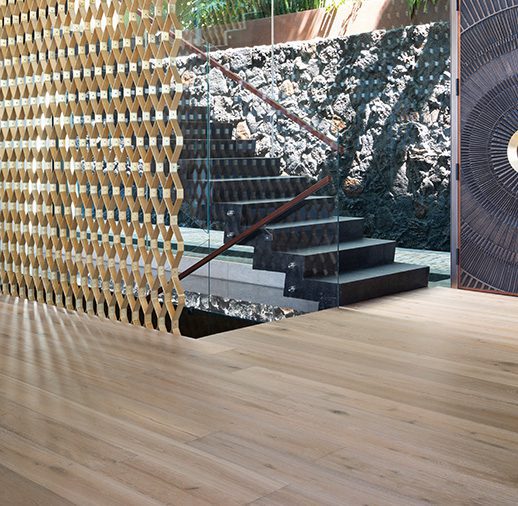 A wooden floor with stairs and a tree in the background
