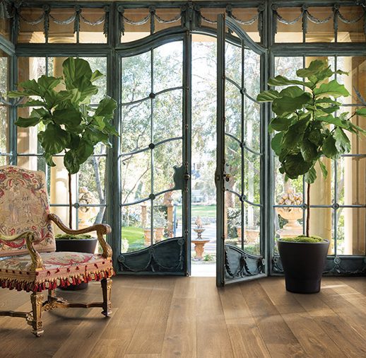 A room with two large windows and a chair