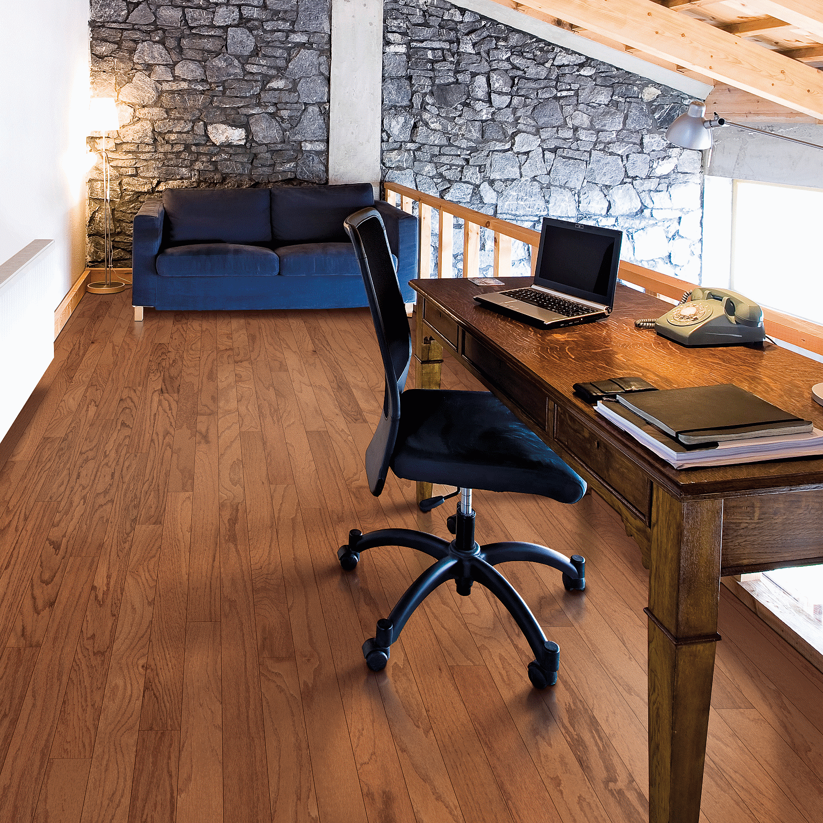 A desk with a laptop and chair in the middle of a room.