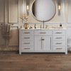A bathroom with white cabinets and a large mirror.