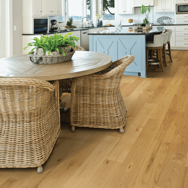 A kitchen with wooden floors and wicker chairs.