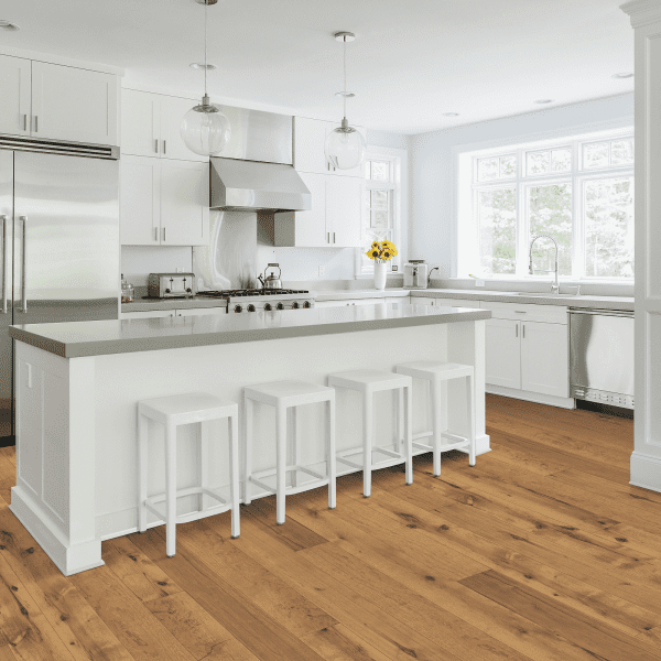 A kitchen with white cabinets and wooden floors.